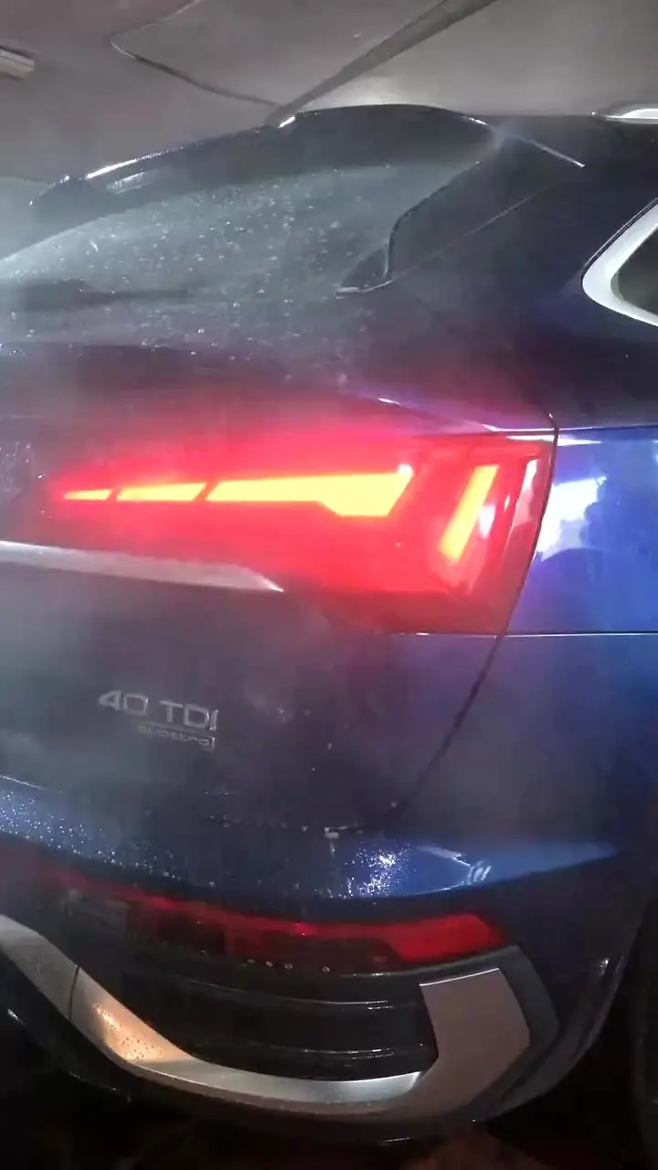 Coche siendo aclarado con agua tras pasar por el túnel de lavado