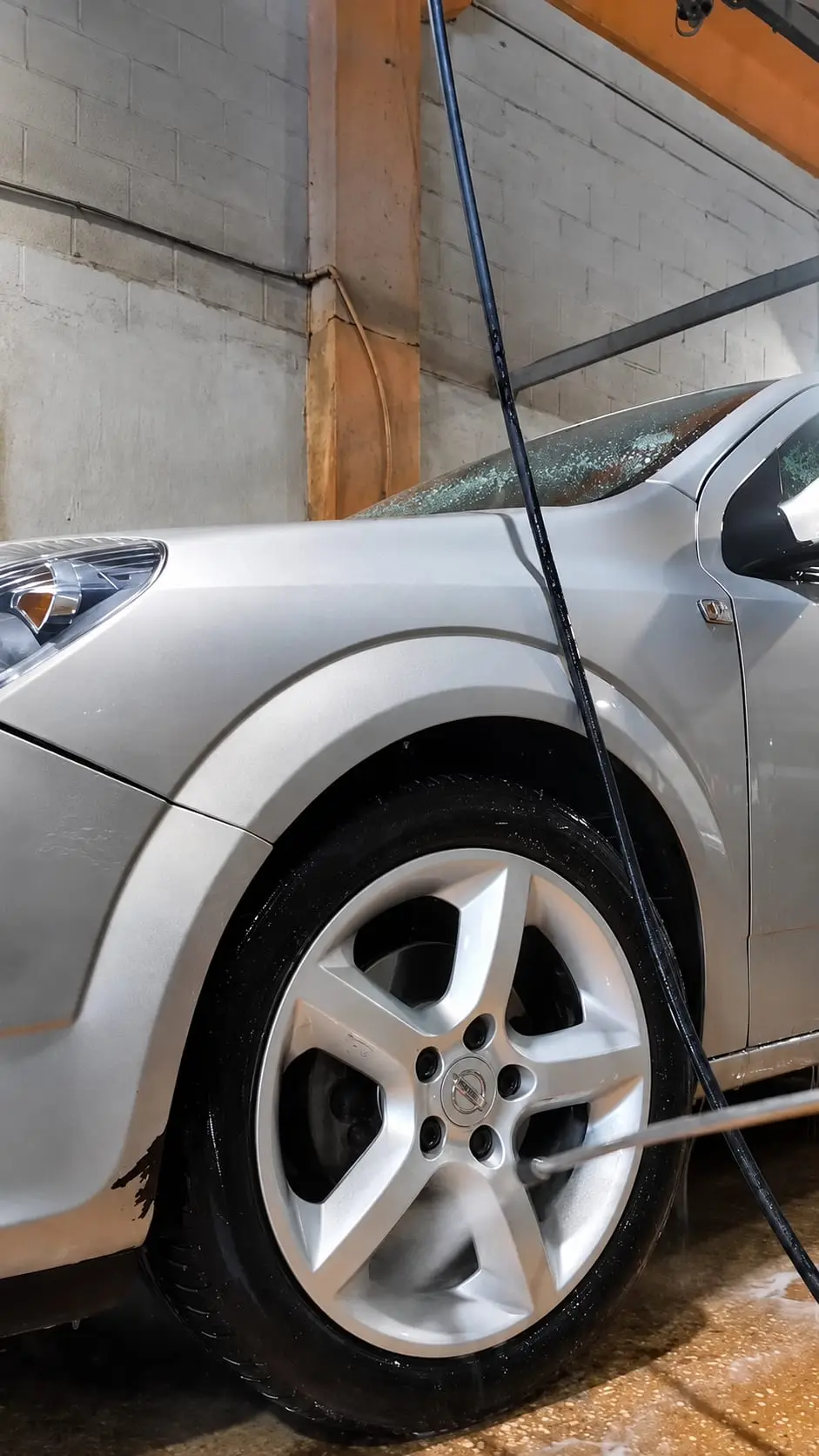 Prelavado de la llanta de un coche con agua a presión
